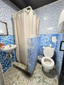 a blue and white bathroom with a toilet and a sink at Cristales de Antigua Hotel Cristal in Antigua Guatemala