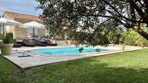a swimming pool in a yard next to a house at La Luberonne gordes in Gordes