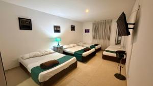 a hotel room with two beds and a television at hotel turqueza inn in Armenia