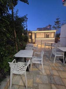 a group of tables and chairs on a patio at Rooftop panoramic jacuzzi room in Ksamil
