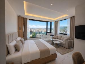 a bedroom with a large bed and a large window at Rooftop panoramic jacuzzi room in Ksamil