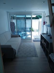 a living room with a couch and a sliding glass door at Mayka in L'Isle-sur-la-Sorgue +18 photos