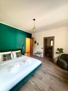 a bedroom with a large bed with a green wall at Escape Room 04 in Tirano +2 photos