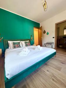 a large bed in a room with a green wall at Escape Room 04 in Tirano