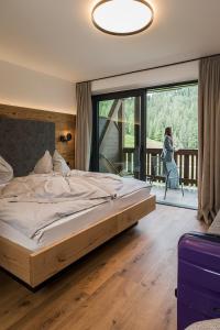 una camera da letto con un grande letto e un balcone di Hotel Wolf a Selva di Val Gardena