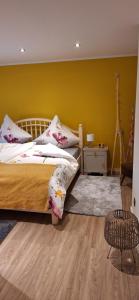a bedroom with a bed and a yellow wall at Ferienwohnung in der Nähe vom Möhnesee-Arnsberg-Breitenbruch in Arnsberg