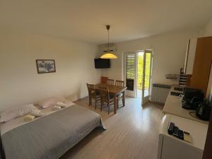 a room with two beds and a table with a dining room at Apartments & Rooms Ribarić in Lovran