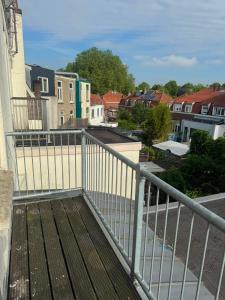 a balcony with a wooden deck with houses in the background at Modern Design Apartment with Balcon in Nijmegen
