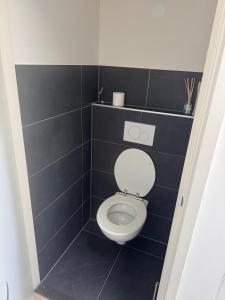 a bathroom with a toilet with black tiles at Modern Design Apartment with Balcon in Nijmegen +5 photos