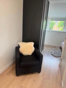 a black chair in a room with a mirror at Modern Design Apartment with Balcon in Nijmegen
