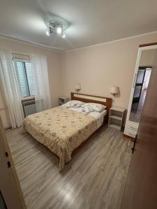 a bedroom with a bed and a wooden floor at Apartments & Rooms Ribarić in Lovran