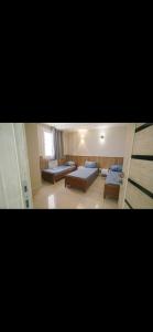 two pictures of a room with two beds in it at مرقد الاخلاص in Fort de lʼEau +3 photos
