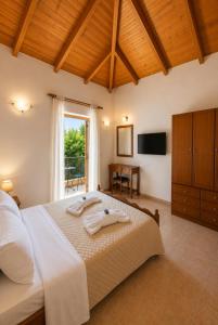 a bedroom with a large bed and a window at Delphinus Villa Nefeli in Agios Nikitas +31 photos