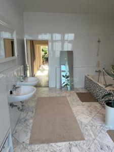 a bathroom with two sinks and a tub and two sinks at Conscious Stay - Mindful Living in Berlin