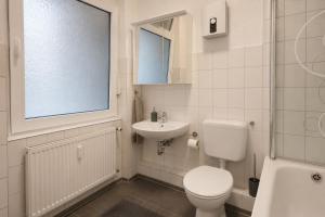 a white bathroom with a toilet and a sink at Koblenz Corner Rooms in Koblenz +8 photos