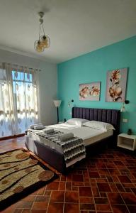 a large bed in a bedroom with blue walls at Vizion Hotel in Shkodër