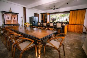 a dining room with a large wooden table and chairs at Infinity Whisper in Kosgoda
