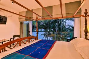 a bedroom with a bed and a large window at Infinity Whisper in Kosgoda