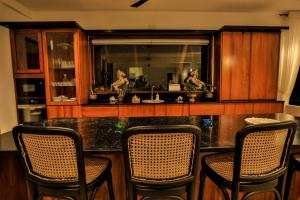 a kitchen with a bar with chairs and a counter top at Infinity Whisper in Kosgoda +7 photos