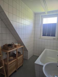 a bathroom with a sink and a bath tub at Gemütliche Ferienwohung in Neubrandenburg
