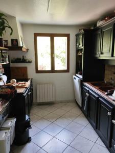 a kitchen with black cabinets and a window at Nahia Etxea agréable maison de 3 chambres in Ciboure
