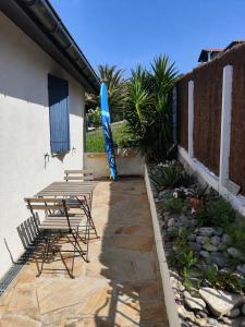 a patio with a table and chairs and an umbrella at Nahia Etxea agréable maison de 3 chambres in Ciboure