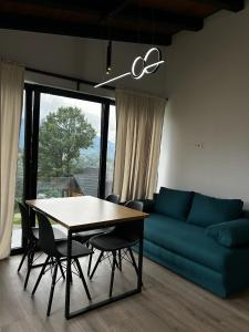 a living room with a table and a blue couch at Aer & Rowa Chalets by Ekow in Statjunea Borsa