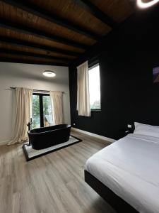 a bedroom with a bed and a bath tub in a room at Aer & Rowa Chalets by Ekow in Statjunea Borsa