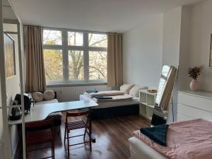 a room with a bed and a desk and a table at Conscious Stay - Mindful Living in Berlin