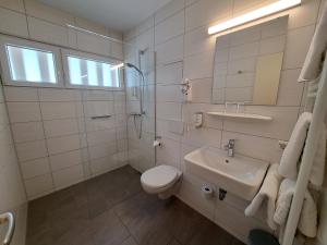 a white bathroom with a toilet and a sink at Hotel zur Post in Weilheim an der Teck +25 photos