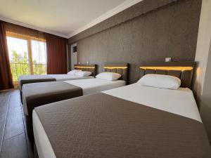 a row of four beds in a room at Paradise House in Pamukkale