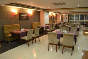 une salle à manger avec des tables et des chaises dans un restaurant dans l'établissement Blue Mercury Hotel, à Erbil