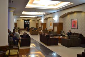 un hall d'entrée avec des personnes assises sur des chaises dans une salle d'attente dans l'établissement Blue Mercury Hotel, à Erbil