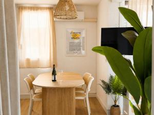 a dining room with a table and a bottle of wine at Résidence de Noëlle in Canet-en-Roussillon