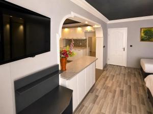 a kitchen with a counter and a television on a wall at Corner Park Suites City Center Corlu in Çorlu