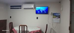 a room with a table and a tv on the wall at Edícula. Ent.independente in Sorocaba
