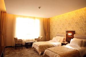 une chambre d'hôtel avec deux lits et une fenêtre dans l'établissement Blue Mercury Hotel, à Erbil 22 autres photos
