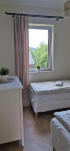 a bedroom with two beds and a window at Domki Partecznik Wisla in Wisła
