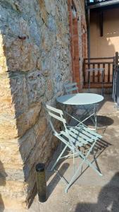 a table and chairs sitting next to a stone wall at Le Temps des Cerises in La Cresse
