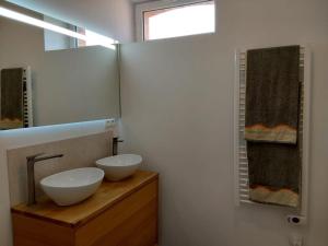 a bathroom with two white bowls on a wooden counter at Le Temps des Cerises in La Cresse