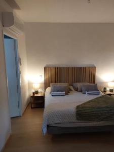 a bedroom with a large bed with a wooden headboard at Le Temps des Cerises in La Cresse