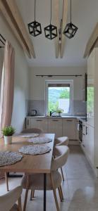 a kitchen with a table and some chairs and a counter at Domki Partecznik Wisla in Wisła