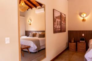 a bedroom with a bed and a mirror at Pousada K in Pirenópolis
