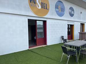 a building with a red door and a table and chairs at HOSTEL Les Bois Verts - Les Herbiers in Les Herbiers +23 photos