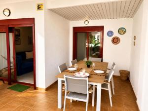 a dining room with a wooden table and chairs at Oasis Palm Mar by HelloApartments in Palm-Mar