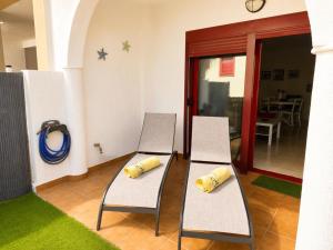 two chairs with pillows on them in a room at Oasis Palm Mar by HelloApartments in Palm-Mar