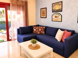a blue couch in a living room with a table at Oasis Palm Mar by HelloApartments in Palm-Mar