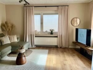 a living room with a couch and a television at LIV Apartments in Stadthagen
