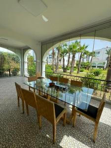 a dining room with a glass table and chairs at Marina Puerto in Marina Smir