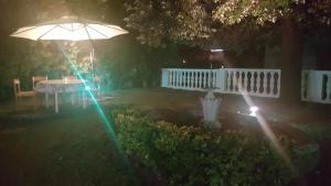 uma mesa e um guarda-chuva num quintal à noite em Garden Suite em Génova